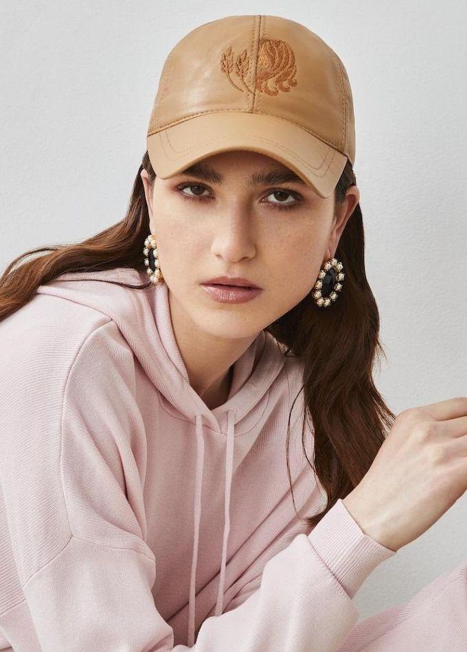 Nude baseball cap with Virgo star sign from Emily London Luxury headwear collection worn by model in pink