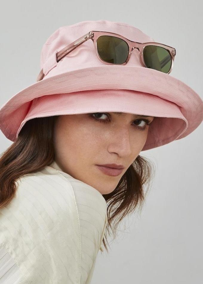 Pink Eden bucket hat paired with aviator sunglasses worn by model wearing white