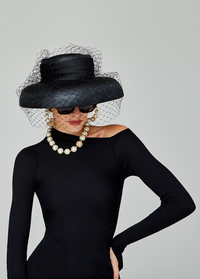 Black Audrey Hepburn style down-brim hat with veil on model
