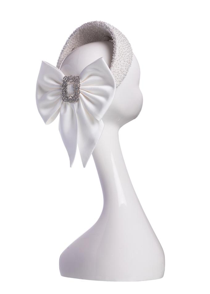 Ivory embellished headpiece with silk bow and crystal brooch on mannequin