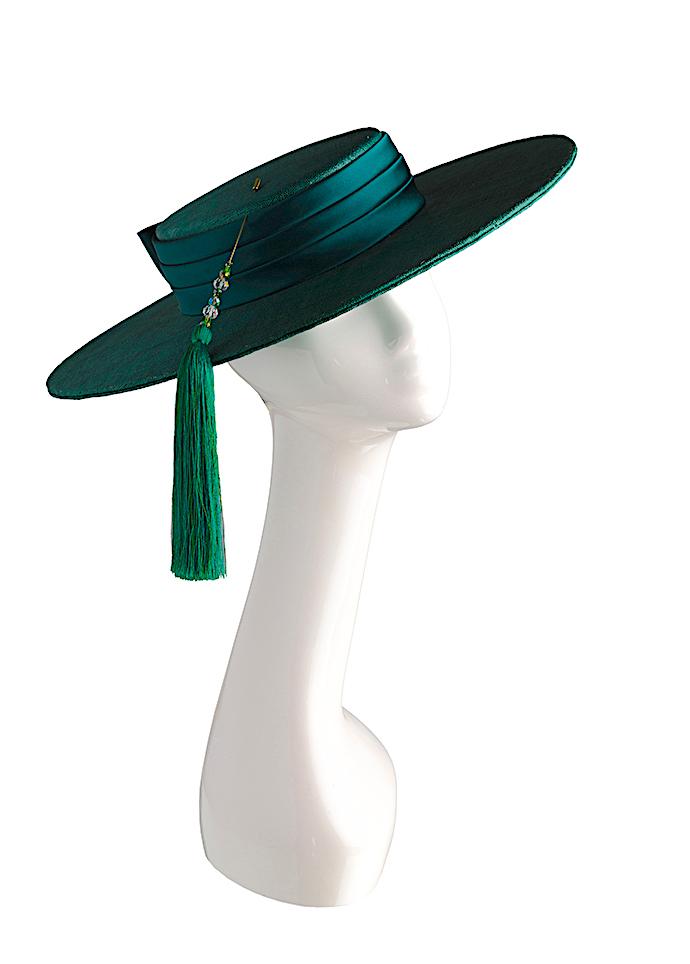 Green straw wide-brimmed boater style hat with silk band and tasselled hat pin