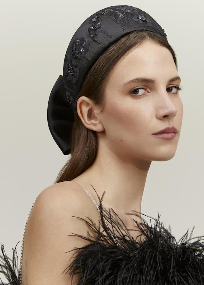Black embroidered floral headpiece with bow on model