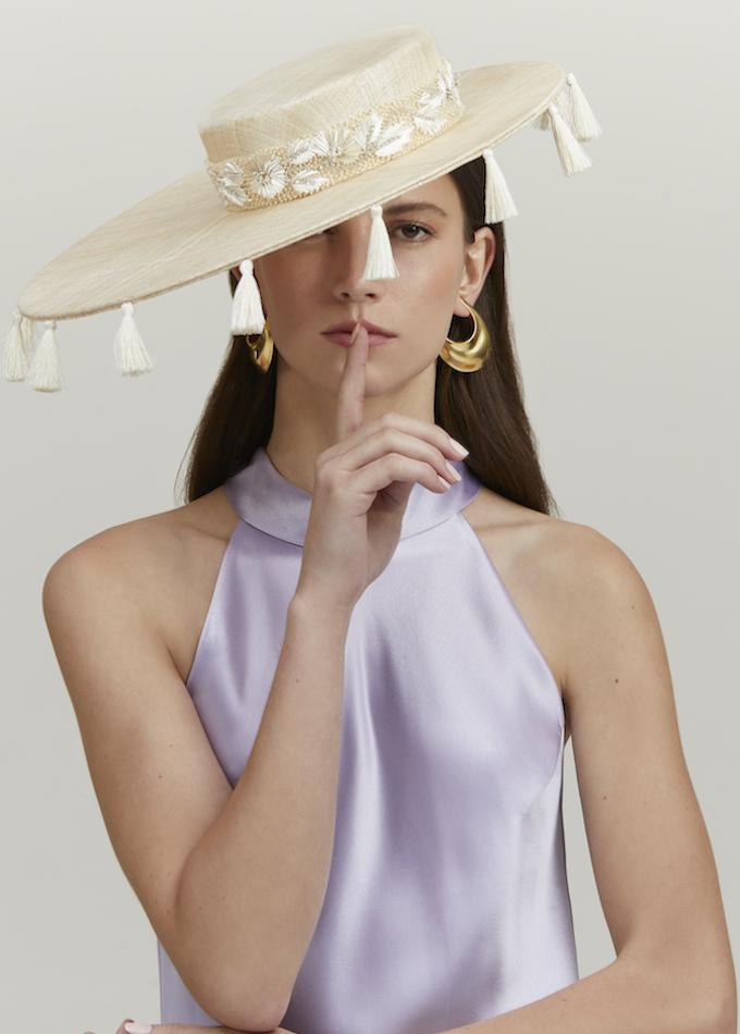 Emily-London wide-brimmed natural straw hat with cream silk tassels on model