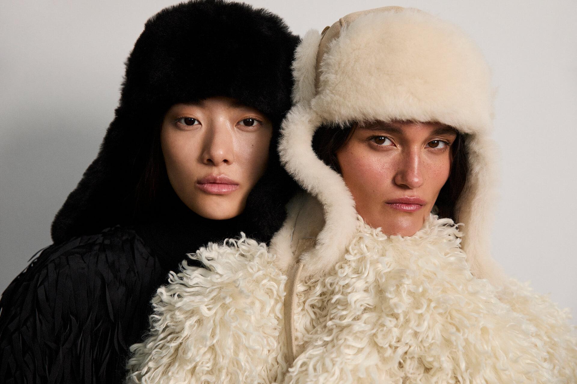 Model shot of two female models wearing the Vermeil Ushanka hats in Black and Tan sheepskin
